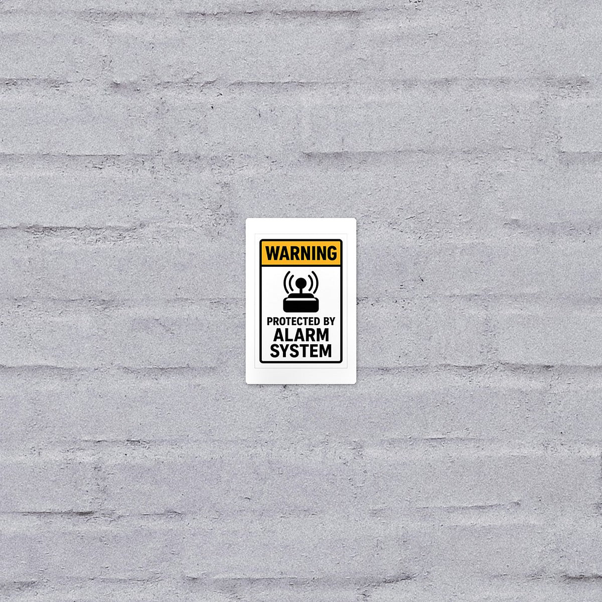 Protected by Alarm System sticker on a brick wall